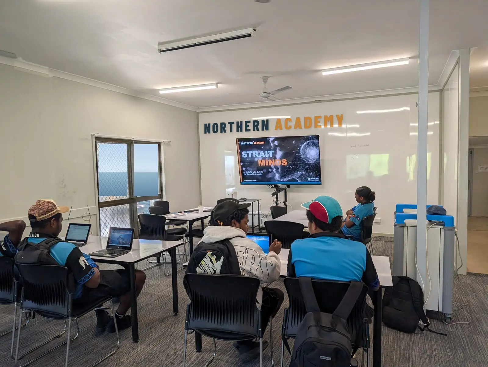 Strait Minds students and facilitator in a classroom with a Northern Academy banner, Thursday Island